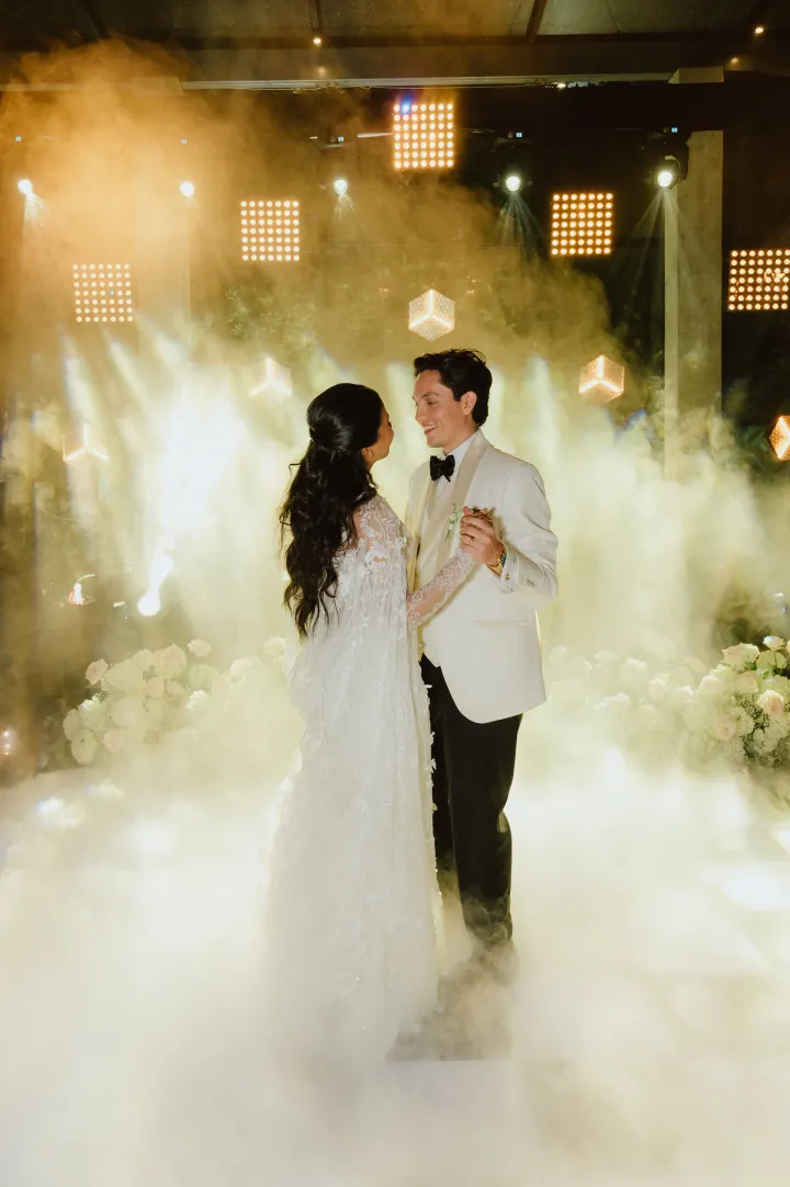 Bride and groom dancing in a luxurious venue.